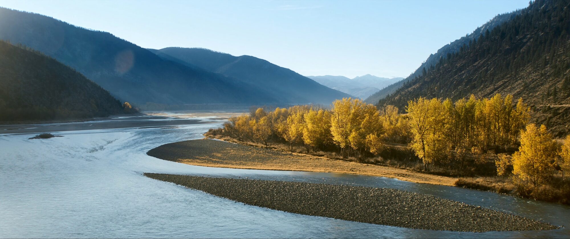A river winding through a Colorado mountain valley at golden hour